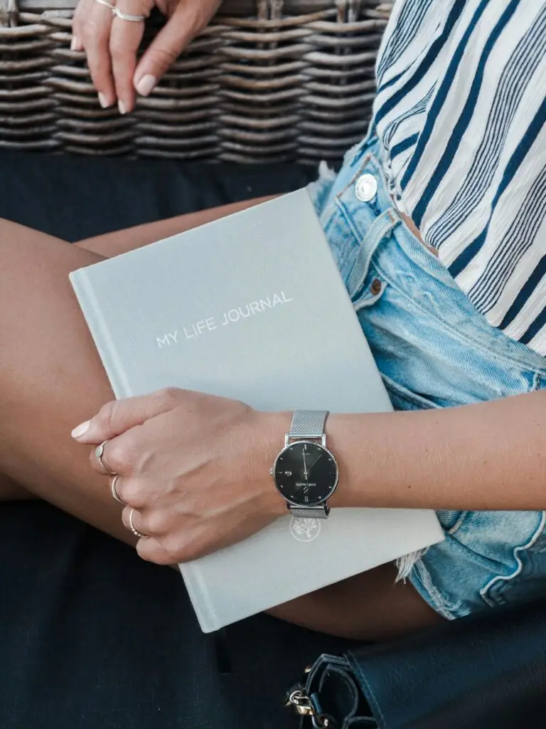 identity exploration Photo shows a woman's torso holding a journal that says "my life journal" against her side.