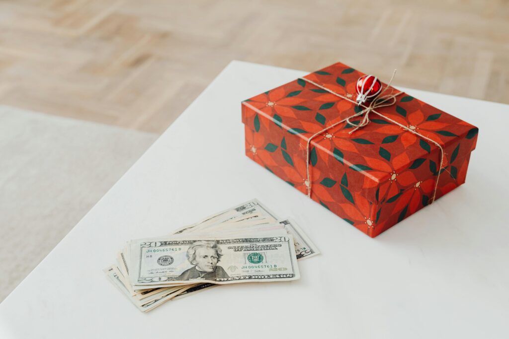 a table with a red wrapped gift and money