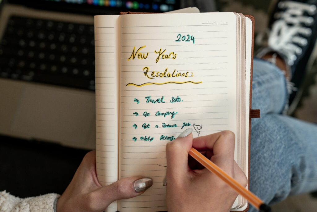 A close up of a notebook with someone writing their new years resolutions