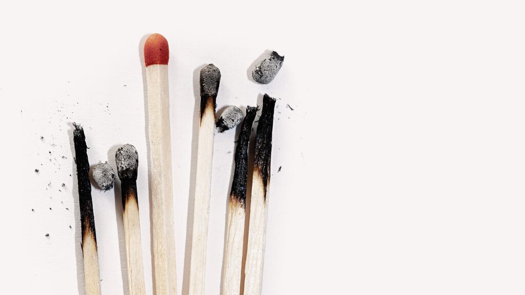 a group of matches with one in tact while the others are burnt out.